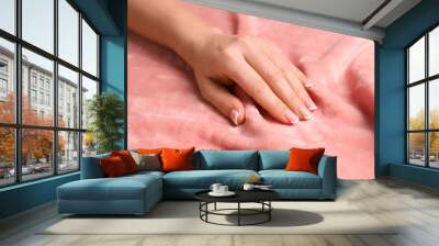 Woman touching soft pink fabric, closeup view Wall mural