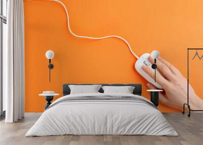 Woman using modern wired optical mouse on orange background, top view Wall mural