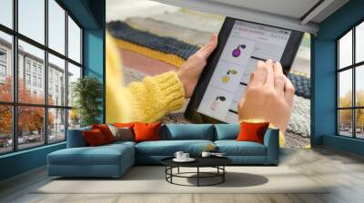 Woman using tablet for online shopping on carpet, closeup Wall mural