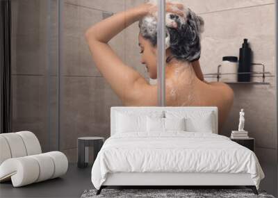 Woman washing hair in shower stall, back view Wall mural