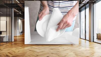 Woman wiping plate with tissue paper at white marble table, closeup Wall mural