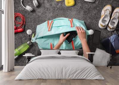 Woman with bag and sports items on grey carpet, top view Wall mural