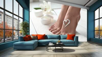 Woman with beautiful feet and cream on white towel, closeup. Spa treatment Wall mural