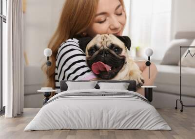 Woman with cute pug dog at home. Animal adoption Wall mural