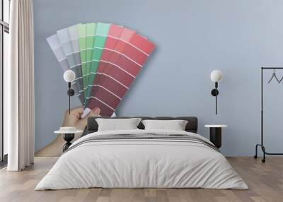 Woman with paint chips choosing color near grey wall, closeup. Interior design Wall mural