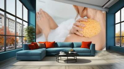 Woman with sponge taking bubble bath, closeup Wall mural