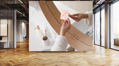 Woman with sticky note saying I Love You near mirror in bathroom, closeup. Romantic message Wall mural