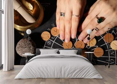 Woman with wooden runes at divination mat indoors, top view Wall mural