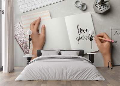 Woman writing LOVE YOURSELF in journal on grey table, flat lay Wall mural