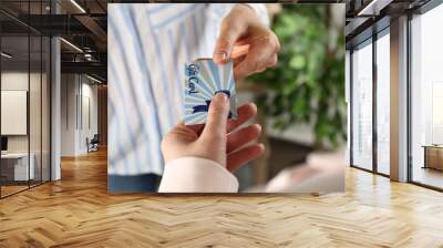 Women with gift card on blurred background, closeup Wall mural