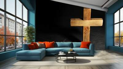 Wooden Christian cross on black slate table against dark background, above view with space for text. Religion concept Wall mural