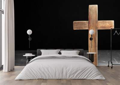 Wooden Christian cross on brown marble table against black background, space for text. Religion concept Wall mural