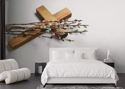 Wooden cross and willow branches on light grey background, space for text. Easter attributes Wall mural