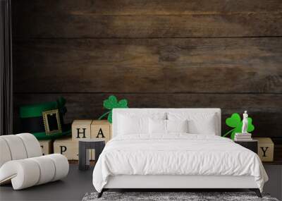 Wooden cubes with words HAPPY ST PATRICK'S DAY, green leprechaun hat and clover leaves on table Wall mural