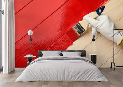 Worker in gloves painting wooden surface with red dye, top view. Space for text Wall mural