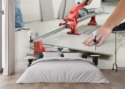 Worker using manual tile cutter indoors, closeup Wall mural