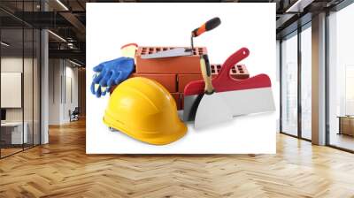 Yellow hard hat, red bricks, gloves, trowel and putty knives isolated on white. Building material and construction tools Wall mural