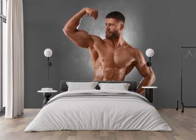 Young bodybuilder with muscular body on grey background Wall mural