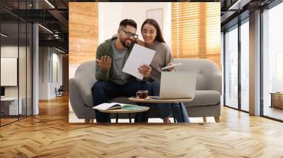 Young couple discussing family budget at home Wall mural