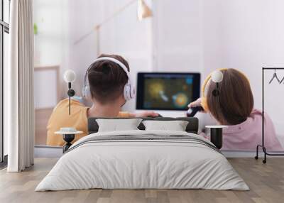 Young couple playing video games at home Wall mural