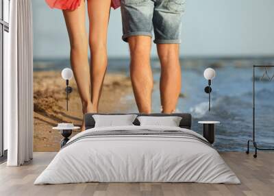 Young couple spending time together on beach, closeup of legs Wall mural