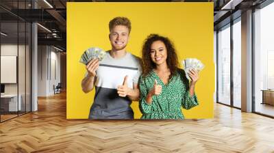 Young couple with money on color background Wall mural