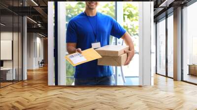 young courier holding parcels on doorstep, closeup. delivery service Wall mural