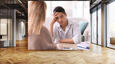 Young female psychologist working with teenage boy in office Wall mural