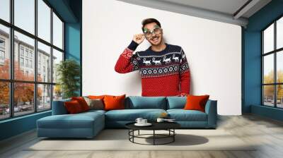 Young man in Christmas sweater with party glasses on white background Wall mural