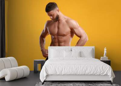 Young man is stylish black underwear on orange background Wall mural