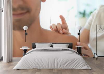 Young man undergoing acupuncture treatment in salon, closeup Wall mural