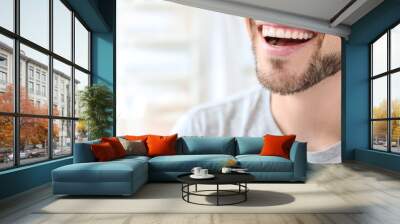 Young man with beautiful smile indoors. Teeth whitening Wall mural