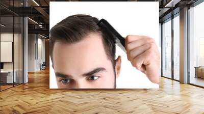 Young man with comb on white background, closeup. Hair loss problem Wall mural