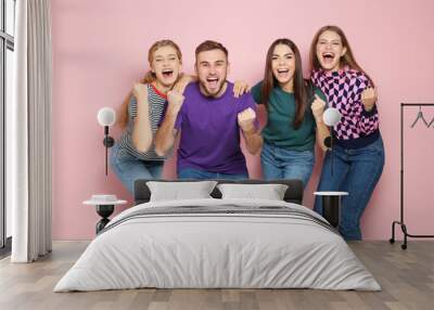 Young people celebrating victory on color background Wall mural