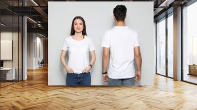 Young people in t-shirts on light background. Mock up for design Wall mural