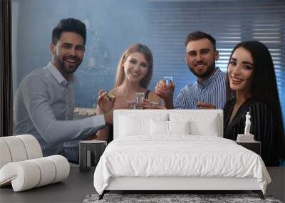 Young people toasting with Mexican Tequila shots at table in bar Wall mural