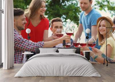 Young people with glasses of wine at table outdoors. Summer barbecue Wall mural