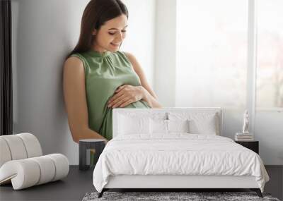 Young pregnant woman near window at home Wall mural