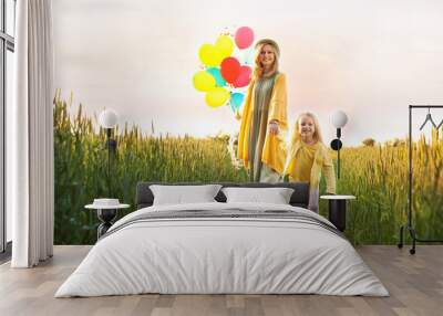 Young woman and her daughter with colorful balloons outdoors on sunny day Wall mural