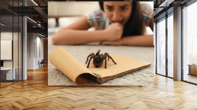 Young woman and tarantula on carpet. Arachnophobia (fear of spiders) Wall mural