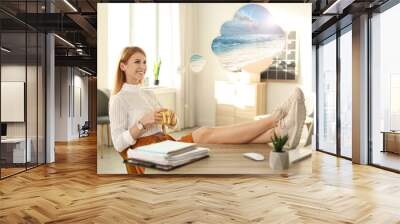 Young woman dreaming about vacation at table in office Wall mural