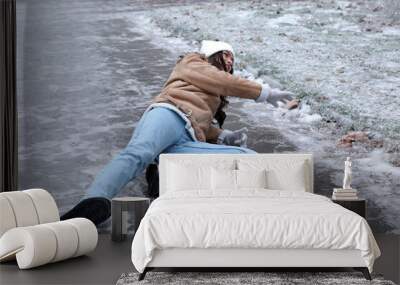 Young woman fallen on slippery icy pavement outdoors Wall mural