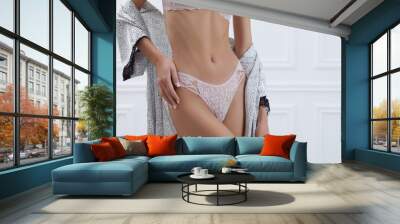 Young woman in elegant underwear and robe near white wall, closeup Wall mural