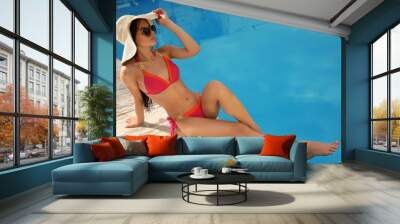 Young woman in stylish pink bikini near swimming pool. Space for text Wall mural