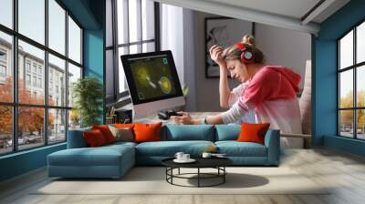 Young woman playing video game at home Wall mural