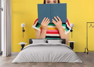 Young woman reading book on color background, space for text Wall mural