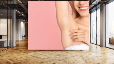 Young woman showing armpit with smooth clean skin on pink background, closeup. Space for text Wall mural