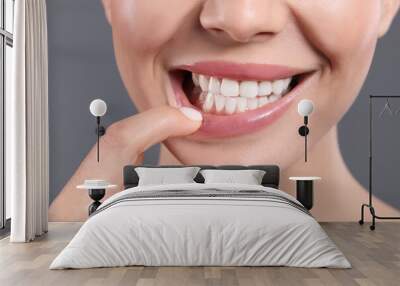 Young woman showing healthy gums on grey background, closeup Wall mural