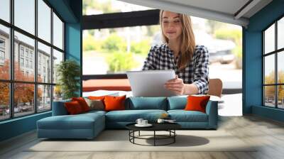 Young woman studying with tablet at table in library Wall mural