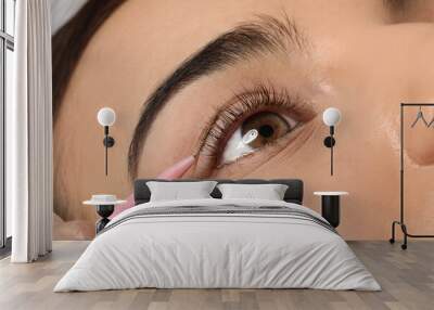 Young woman undergoing eyelash lamination, closeup. Professional service Wall mural